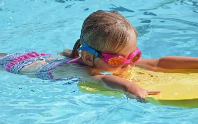 Une petite fille nageant en profitant de la piscine