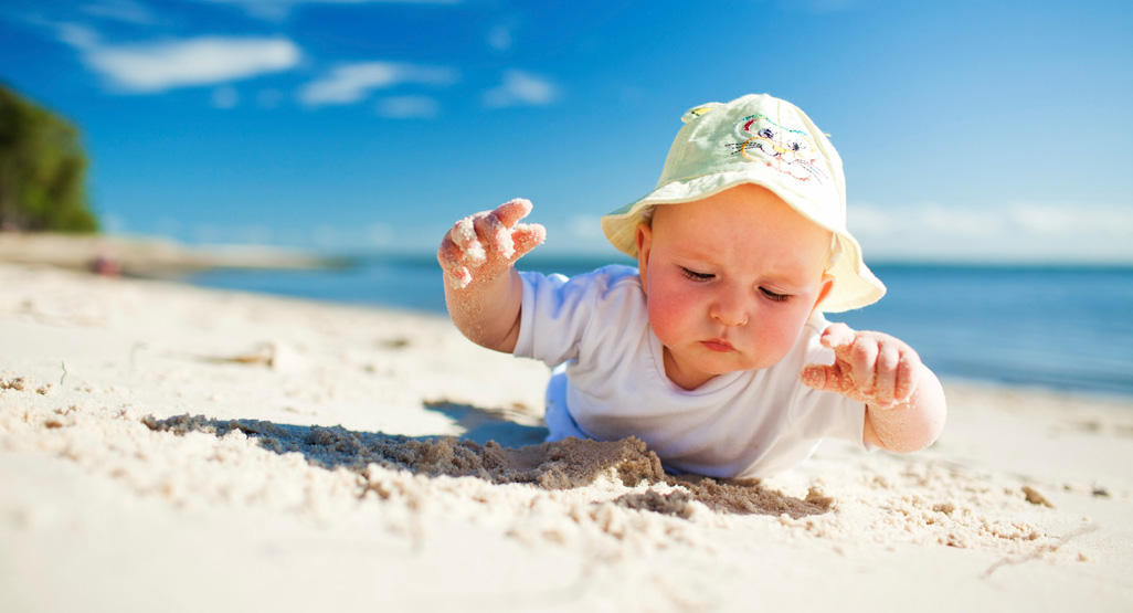 a baby on the sand of a beach